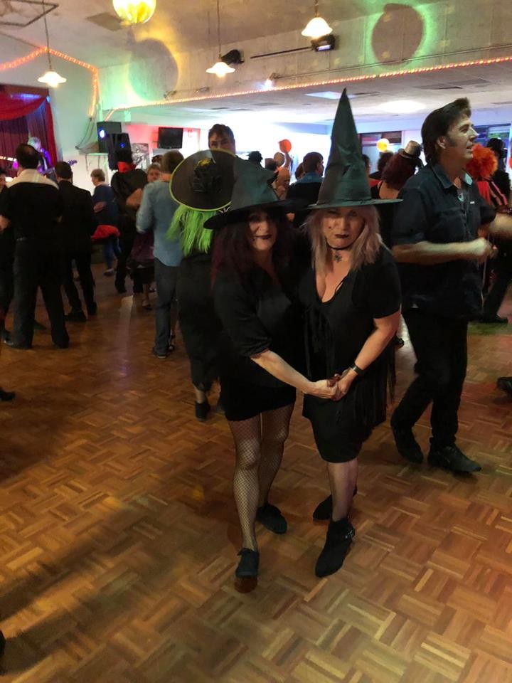 Two ladies dressed as witches for halloween dancing rock n roll together at the British Working Mens Club in Wingfield